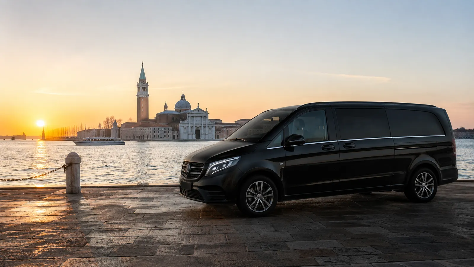Van Mercedes nero con autista privato al tramonto davanti all'isola di San Giorgio Maggiore, Venezia
